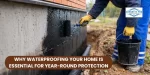Worker applying waterproofing coating to house foundation wall to prevent water damage